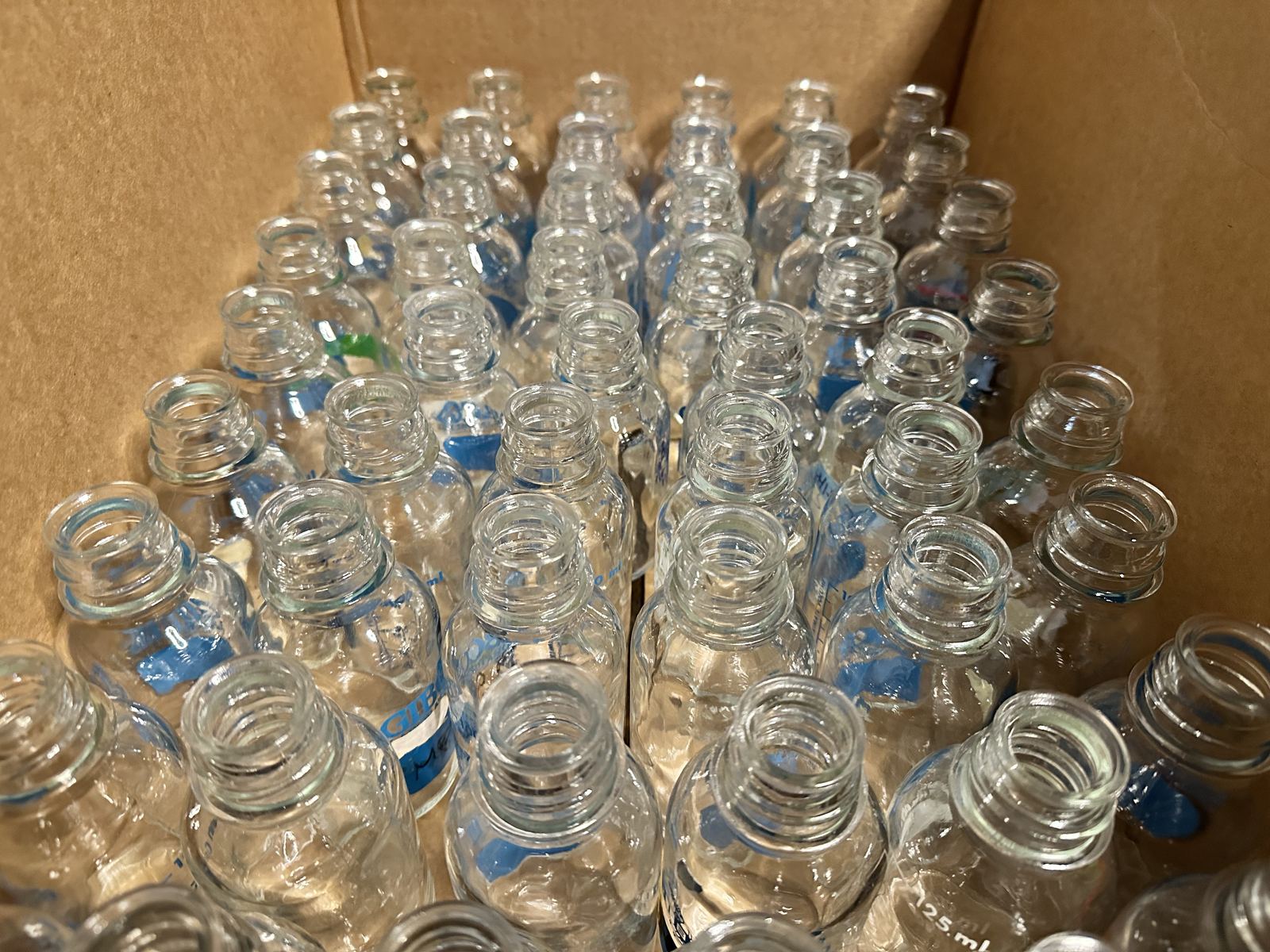 Box of glass laboratory bottles prepared for donation