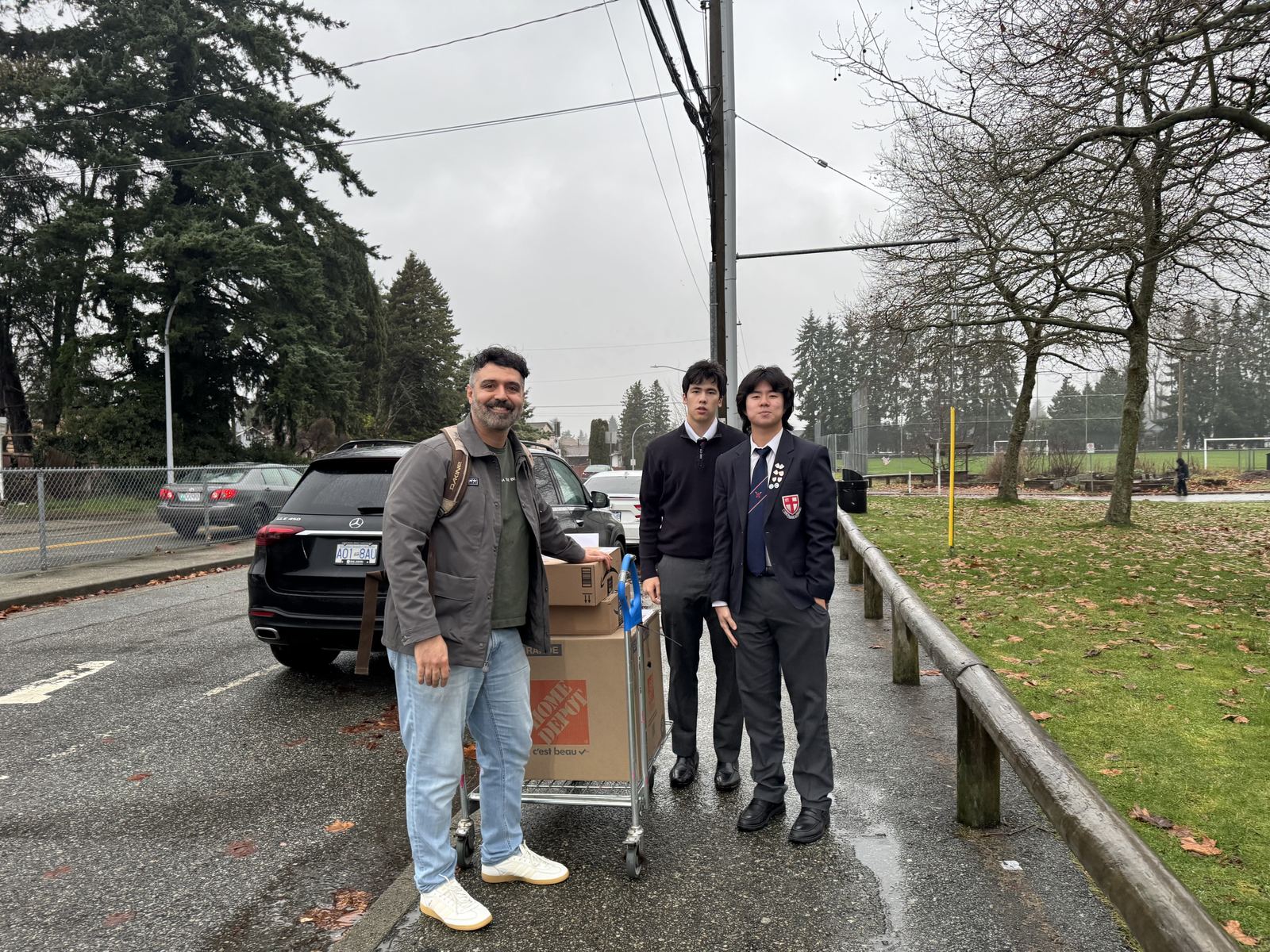 Volunteers delivering boxes of donated equipment to a school
