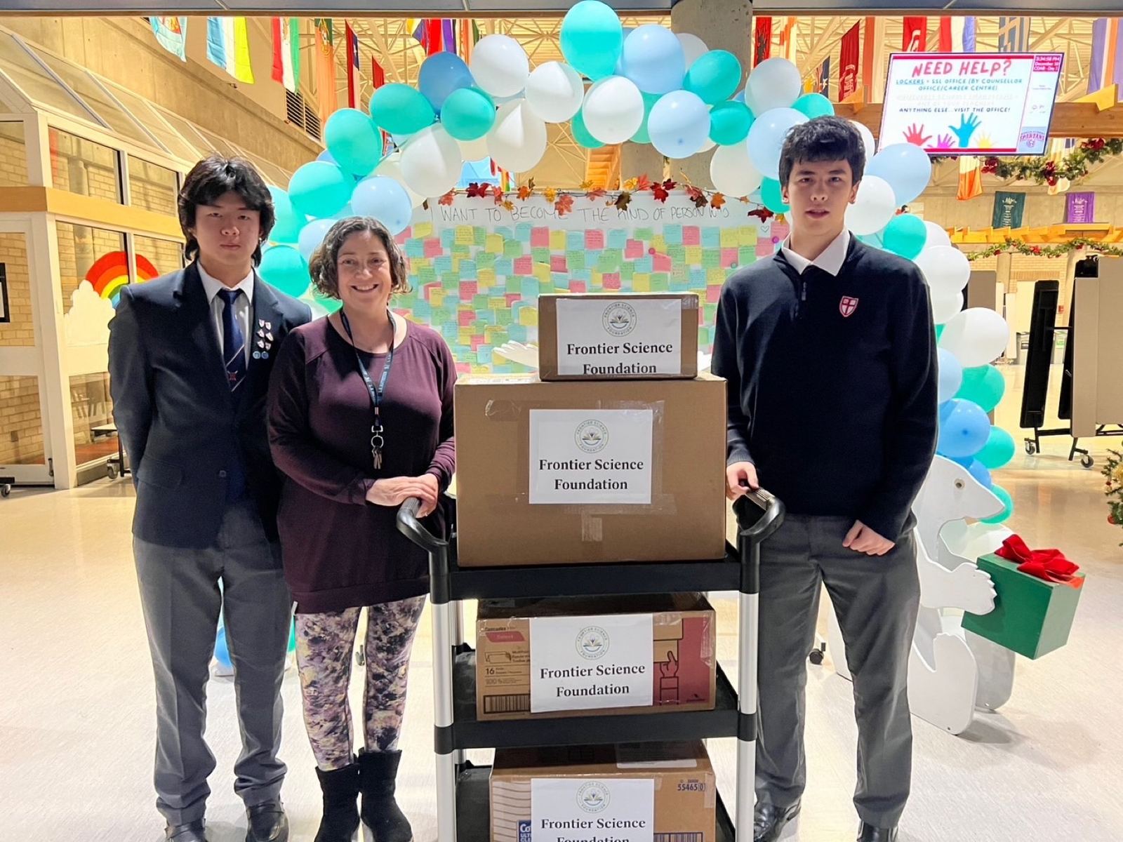 Students presenting boxes of donated supplies to a school